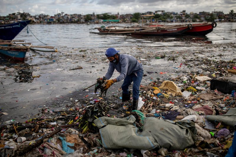 Argie Aguirre, a member of the River Warriors, gathers trash from the polluted Pasig River in Manila, Philippines, June 22, 2021. Pope Francis intensified his calls for caring for creation ahead of "Earth Overshoot Day," the day when resource consumption goes into "debt" because the annual demand on nature exceeds what the earth can regenerate in that year. That day fell on July 28 this year. (CNS photo/Eloisa Lopez, Reuters)