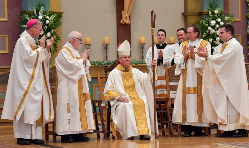 Bishop John P. Dolan, seated, is seen at St. Thomas Aquinas Church in Avondale, Ariz., Aug. 2, 2022, after being installed as the fifth bishop of the Diocese of Phoenix. (CNS photo/Brett Meister, The Catholic Sun)