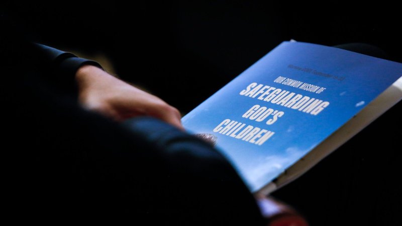 A delegate holds a program during an international conference, "Our Common Mission of Safeguarding God's Children," in Warsaw, Poland, Sept. 21, 2021. A Polish Catholic official defended the church's record in tackling sexual abuse by priests, after the head of the State Commission on Pedophilia complained it was refused access to clerical files. (CNS photo/Polish bishops' conference)