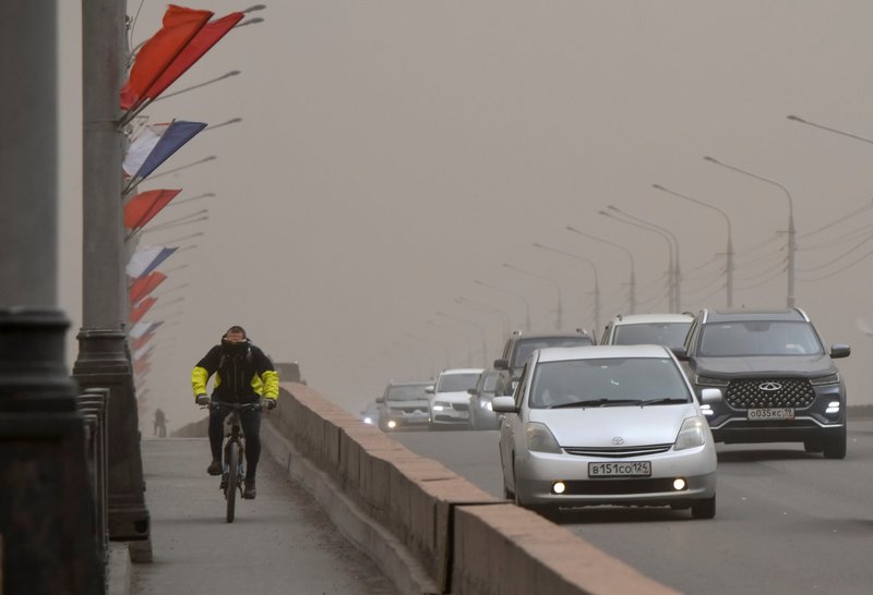 A man rides a bicycle near a traffic way covered with smoke from wildfires in the Siberian city of Krasnoyarsk, Russia, May 7, 2022. Ukrainian bishops have confirmed U.N. reports of mass deportation of Ukrainian civilians to Siberia and Russia's far east. (CNS photo/Alexander Manzyuk, Reuters)