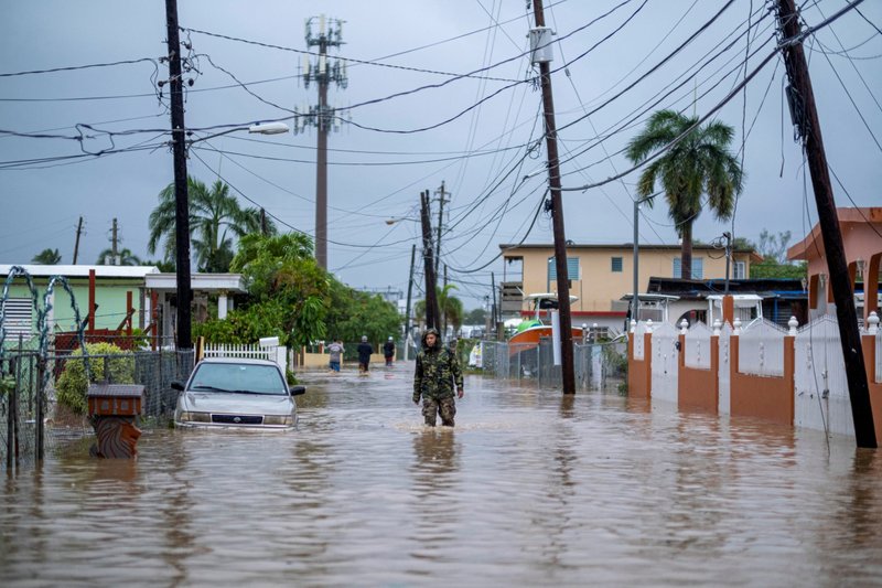 A member of the Puerto Rico National Guard wades through water Sept. 19, 2022, in search for people to be rescued from flooded streets in the aftermath of Hurricane Fiona in Salinas, Puerto Rico. (CNS photo/Ricardo Arduengo)