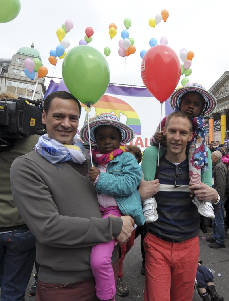 A gay couple holds their adopted children during the Lesbian and Gay Pride rally in central Brussels in this May 18, 2013, file photo. The Flemish-speaking bishops of Belgium have authorized a prayer for committed gay couples on the condition it is clear that it is not equivalent to a wedding blessing. (CNS photo/Laurent Dubrule, Reuters)