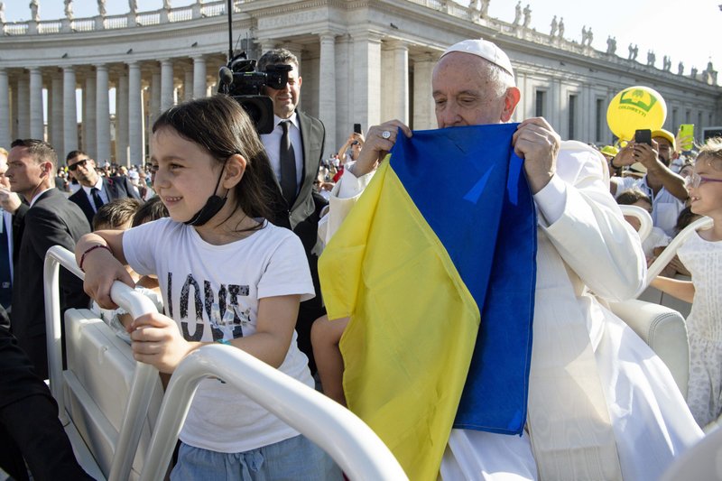 Pope Francis holds a Ukrainian flag as he greets the crowd before Mass in St. Peter's Square during the World Meeting of Families at the Vatican in this June 25, 2022, file photo. Meeting Jesuits in Kazakhstan in early September, the pope said too many people have taken a simplistic view of Russia's war on Ukraine. (CNS photo/Vatican Media)