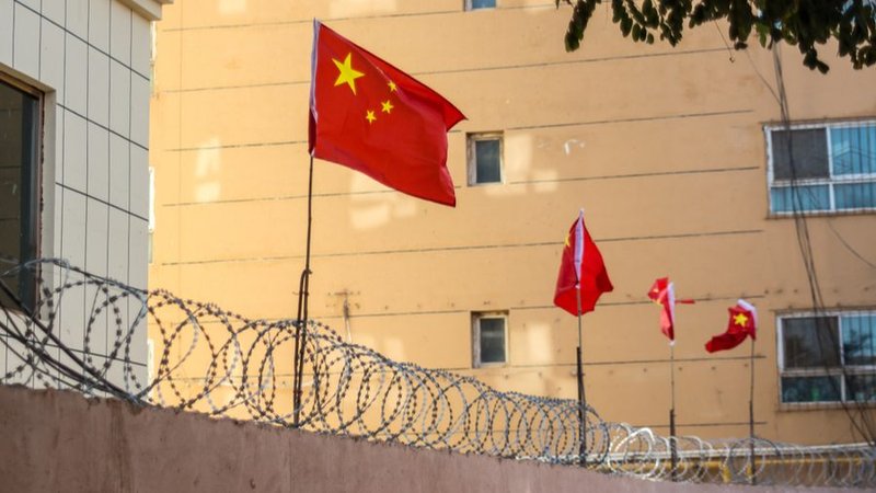 Chinese flags on barbed wired wall in Kashgar (Kashi), Xinjiang, China. (Jonathan Densford/Shutterstock via CNA)