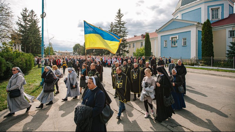 A man carries a Ukrainian flag during a procession in celebration of the special day of prayer for Ukraine in Shargorod, Ukraine, Sept. 14, 2022, the feast of the Exaltation of the Holy Cross. (CNS photo/Vyacheslav Sokolovy)