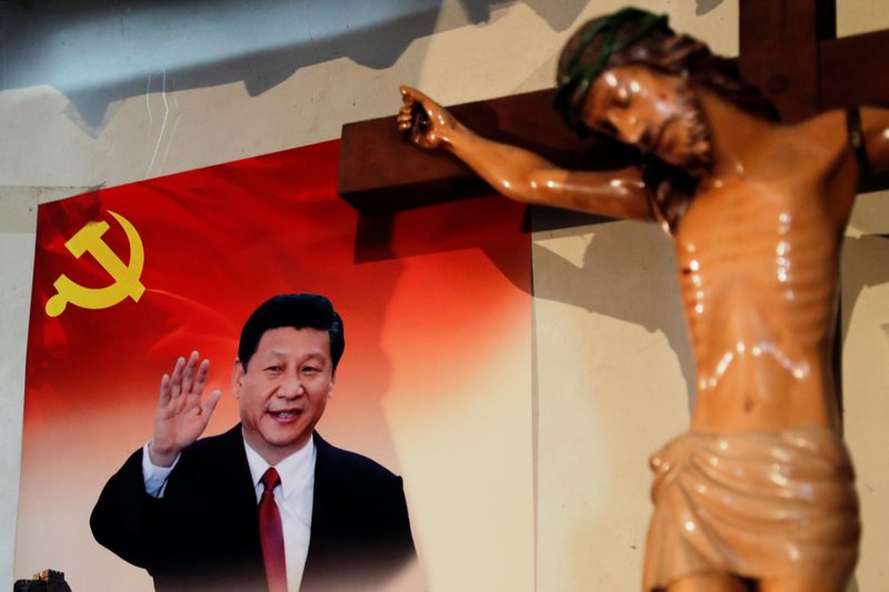 A poster of Chinese President Xi Jinping hangs next to a crucifix on the wall of the house of a Tibetan Catholic on Christmas Eve in Niuren village, in China's Yunnan province, in this Dec. 24, 2018, file photo. (CNS photo/Tyrone Siu, Reuters)