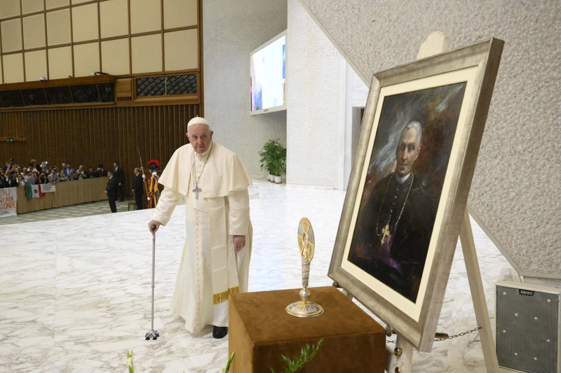 Pope Francis walks by an image and relic of St. Giovanni Battista Scalabrini in the Vatican audience hall Oct. 10, 2022, during a meeting with pilgrims who had come to Rome for the Italian priest's canonization. St. Scalabrini founded a religious order that ministers to migrants and refugees. (CNS photo/Vatican Media)