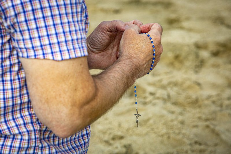 Pete Munsey of Baltimore prays the rosary in Rehoboth Beach, Del., May 23, 2021. (CNS photo/Chaz Muth)