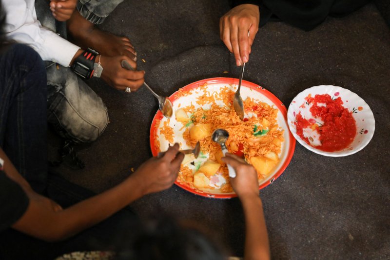 A woman and her children share food at their dwelling in Sanaa, Yemen, Aug. 29, 2022. Marking the U.N.'s celebration of World Food Day, Oct. 16, Pope Francis said acts of love and solidarity are key to fighting hunger. (CNS photo/Khaled Abdullah, Reuters)