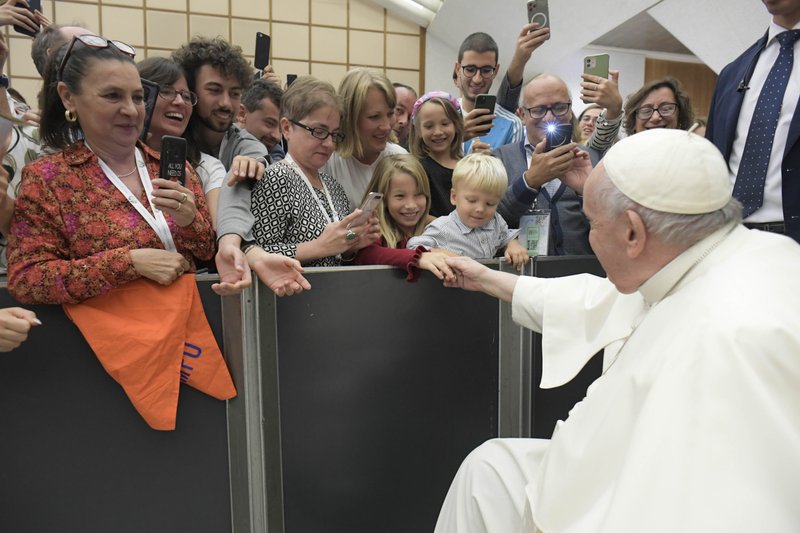 Pope Francis shakes hands with a child during an audience at the Vatican with members of the young adult section of Italy's Catholic Action, Oct. 29, 2022. (CNS photo/Vatican Media)