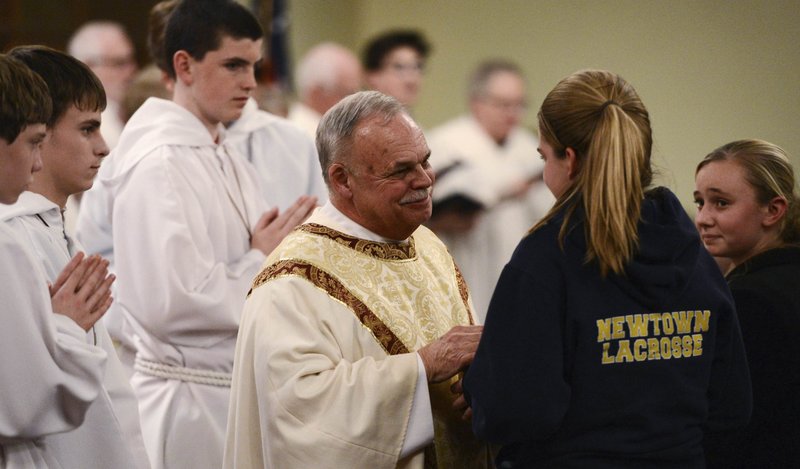 Msgr. Robert Weiss speaks to young women inside St. Rose of Lima Church during a vigil service the evening of the Sandy Hook shooting Dec. 14, 2012 in Newtown, Conn. Eight of the children who died in the shooting were St. Rose parishioners and Weiss presided over their funerals. (CNS photo/Andrew Gombert, pool via Reuters)