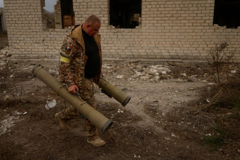 A Ukrainian serviceman in the Kherson region carries captured anti-tank grenade launchers at a former Russian position Nov. 11, 2022. (CNS photo/Valentyn Ogirenko, Reuters)