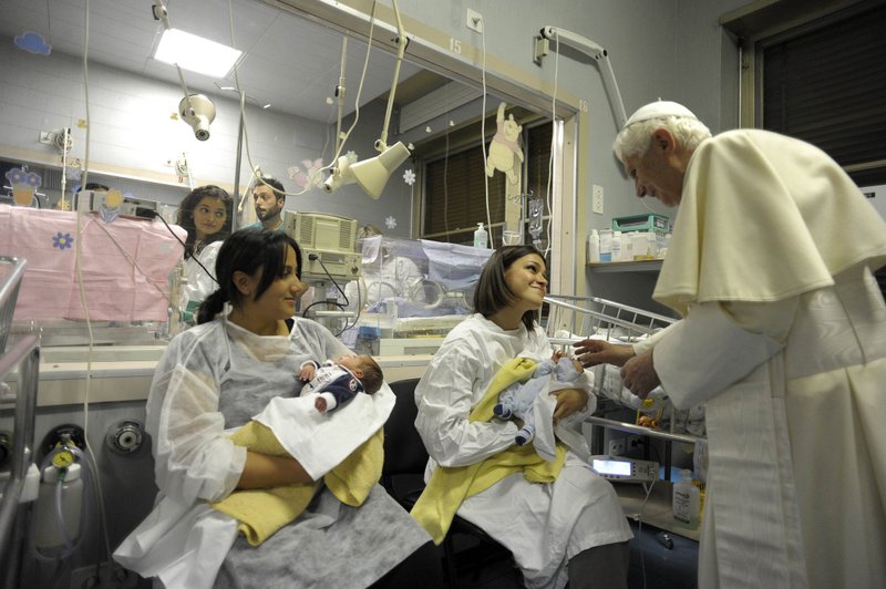 Pope Benedict XVI talks to women holding babies during his visit to Rome's Gemelli Hospital in 2010. (CNS photo/L'Osservatore Romano via Reuters) (Jan. 6, 2010) See POPE-EPIPHANY Jan. 6, 2011. Editors: for editorial use only.