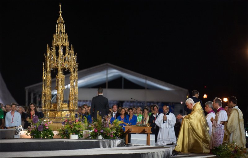 Pilgrims join Pope Benedict XVI in Eucharistic adoration during the World Youth Day prayer vigil at Cuatro Vientos airfield in Madrid Aug. 20, 2011. Despite enduring a downpour during the vigil, hundreds of thousands of young people from around the world spent the night on the open field. (CNS photo/Alessia Giuliani, Catholic Press Photo)