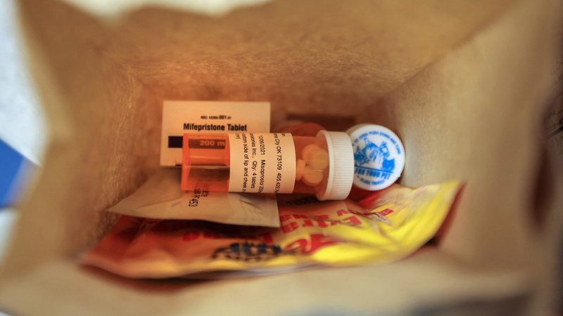An illustration shows a paper bag containing the mifepristone and misoprostol pills used for a chemical abortion, follow-up instructions and small warming packs. (OSV News photo/Evelyn Hockstein, Reuters)