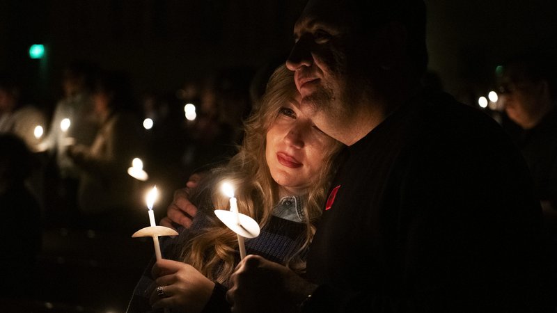 A couple is lit by the glow of the Paschal Candle spread via smaller candles during the Easter Vigil Mass at Cathedral of Our Lady of the Angels on April 8. (Victor Alemán)