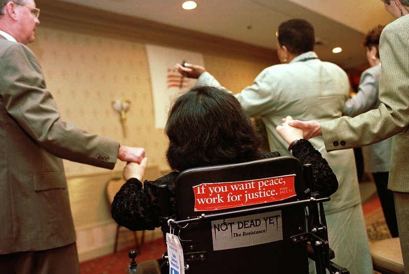 Messages on the back of Lillibeth Navarro's wheelchair announce the causes she works for in her effort to protect and enhance the lives of persons with disabilities, in this 2000 file photo. (CNS/Nancy Wiechec)