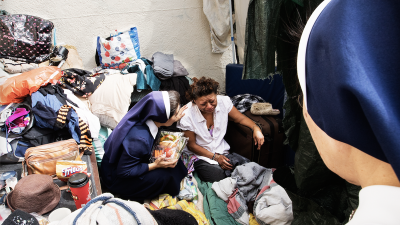 Sister Rosaline Vu comforts a homeless woman in Los Angeles in this 2016 file photo.The sisters, Lovers of the Holy Cross of Los Angeles, have a mobile outreach to the homeless as part of the Good Shepherd Center. (Victor Alemán)