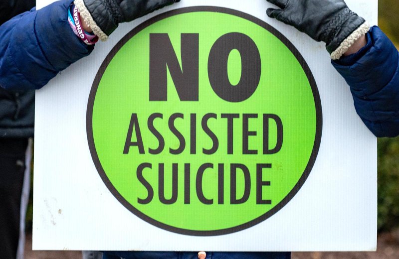 A person is pictured in a file photo holding a sign against physician-assisted suicide. The California Department of Public Health's "End of Life Option Act 2022 Data Report," released in July 2023, shows there has been a 63% increase in requests for life-ending drugs, with 853 eventual deaths, since the state relaxed its physician-assisted death rules in 2021. (OSV News/Kevin J. Parks, Catholic Review)