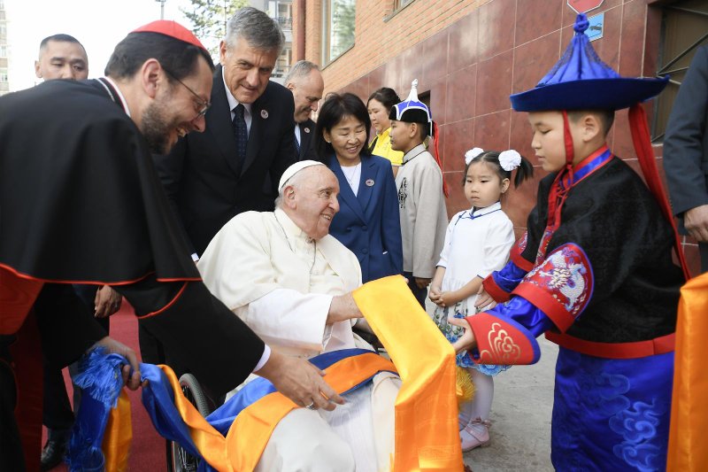 A boy gives Pope Francis scarves as he arrives at the headquarters of the Apostolic Prefecture of Ulaanbaatar, Mongolia, Sept. 1, 2023. Cardinal Giorgio Marengo, the prefect, will host the pope at the prefecture during his four-day visit to the country. (CNS/Vatican Media)
