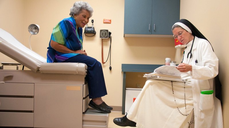 Dominican Sister Mary Diana Dreger, a medical doctor, talks with a patient in 2011 at St. Thomas Family Health Center South in Nashville, Tenn. The Catholic Medical Association's annual conference in Phoenix Sept. 7-9, 2023, is focusing on courage and why this virtue is especially important in the medical field today. (OSV News/Theresa Laurence, Tennessee Register)