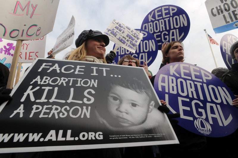 Maria Burud, left, of Madison, Wis., is pictured in a file photo holding a pro-life sign next to demonstrators for legal abortion outside the Supreme Court building in Washington. The Wisconsin Catholic bishops have expressed "deep sadness and dismay" that Planned Parenthood plans to resume abortions in Wisconsin, adding that "taking a human life is not health care." (OSV News/CNS file, Peter Lockley)