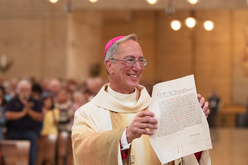 Bishop Marc V. Trudeau shows the papal decree announcing his appointment as an auxiliary bishop of Los Angeles — and as bishop of the titular see of Tinisa in Proconsulari — at his episcopal ordination June 7, 2018. (Victor Alemán)