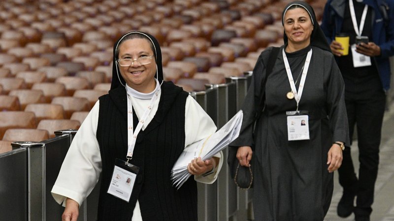 Sister Loida Lim, a member of the Missionaries of St. Dominic, and Sister Caroline Saheed Jarjis, a member of the Daughters of the Sacred Heart of Jesus, arrive for the afternoon session of the assembly of the Synod of Bishops in the Paul VI Audience Hall at the Vatican Oct. 13, 2023. (CNS/Vatican Media)