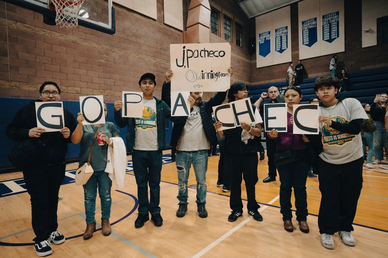 Fans of LA seminarian Jose Pacheco hold up signs of support at the Priests vs. Seminarians Basketball Game Oct. 13 at Cathedral High School. (Peter Lobato)