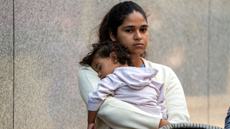 A migrant and her daughter wait for aid outside the offices of Catholic Charities in New York City Aug. 16, 2022, after being transported via charter bus from Texas. (OSV News/David Delgado, Reuters)