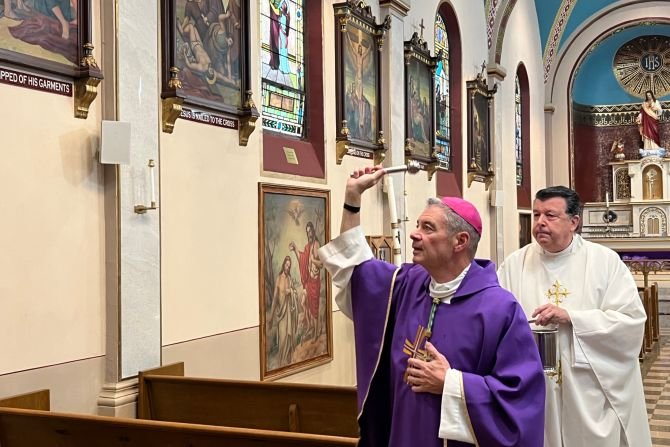 Bishop Robert Brennan blesses Annunciation of the Blessed Virgin Mary Church in Brooklyn, New York, with holy water on Nov. 4, 2023, in response to the filming of an indecent music video in the church. Assisting the bishop is Monsignor Joseph Grimaldi, vicar general of the Diocese of Brooklyn. (John Quaglione/DeSales Media via CNA)