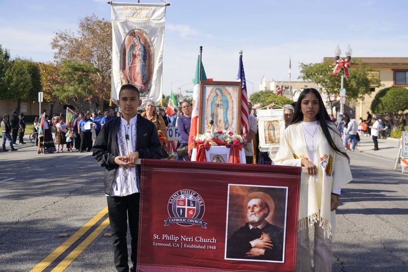 Parishioners from St. Philip Neri Church walk with their sign during the 92nd Procession and Mass honoring Our Lady of Guadalupe and St. Juan Diego on Dec. 3. (Sarah Yaklic)