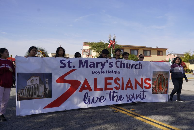 Parishioners from St. Mary's Church in Boyle Heights walk with their sign during the 92nd Procession and Mass honoring Our Lady of Guadalupe and St. Juan Diego on Dec. 3. (Sarah Yaklic)