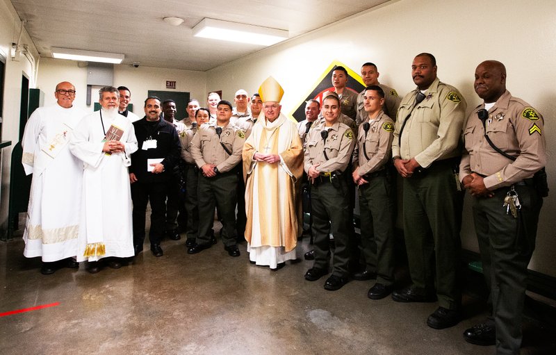 Los Angeles Archbishop José H. Gomez poses with sheriff deputies and others at Men’s Central Jail in Los Angeles where he celebrated Christmas Mass the morning of Dec. 25. (Victor Alemán)