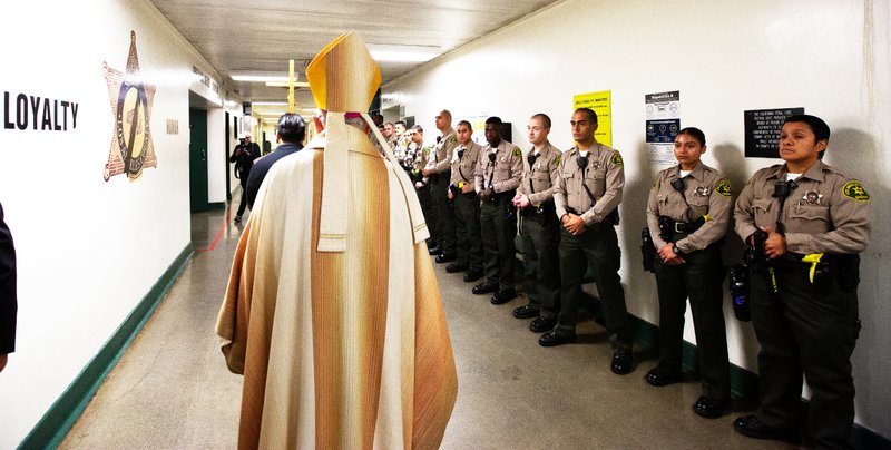 Los Angeles Archbishop José H. Gomez processes past sheriff deputies at Men’s Central Jail in Los Angeles where he celebrated Christmas Mass the morning of Dec. 25. (Victor Alemán)