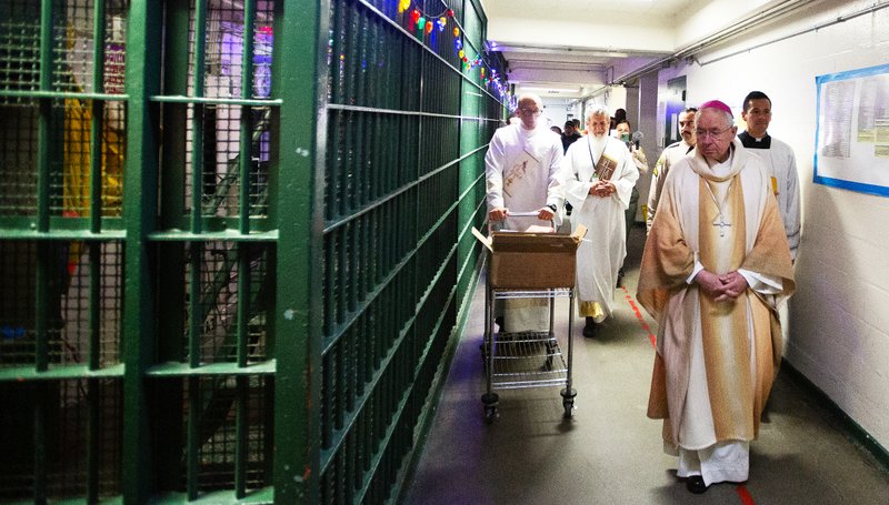 Los Angeles Archbishop José H. Gomez handed out copies of “The Twelve Steps and the Sacraments” by Scott Weeman to inmates at Men’s Central Jail in Los Angeles after celebrating Christmas Mass the morning of Dec. 25. (Victor Alemán)