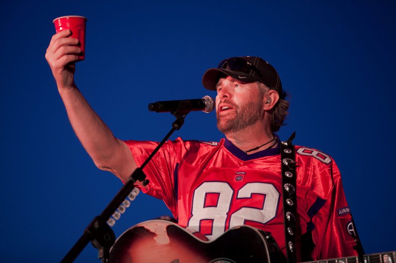 Late country music singer Toby Keith holds up a red Solo cup during his performance for U.S. Service members on Camp Leatherneck, Afghanistan, in April 2012. (DVIDS/Department of Defense, Sgt. Sheila Brooks)