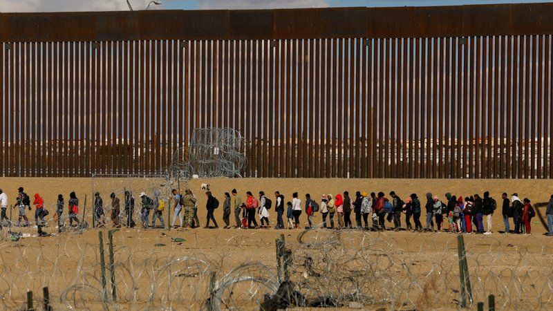 Migrants seeking asylum in the United States gather near the border wall Jan. 22, 2024, as seen from Ciudad Juarez, Mexico, after they crossed a razor wire fence and as members of the Texas National Guard stand guard. (OSV News/Jose Luis Gonzalez, Reuters)