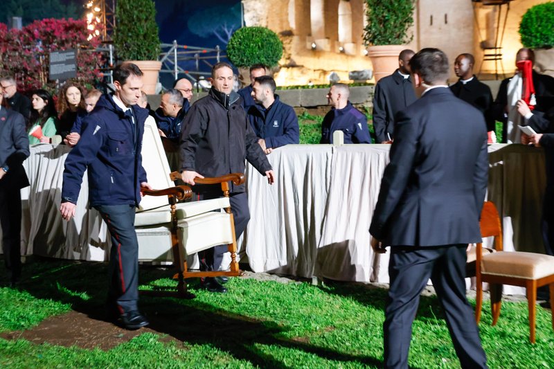 Workers remove the chair that had been set up for Pope Francis atop a hillside overlooking the Colosseum in Rome, after the Vatican announced at the start of the ceremony March 29 that the pope would follow the event from home. (CNS/Lola Gomez)