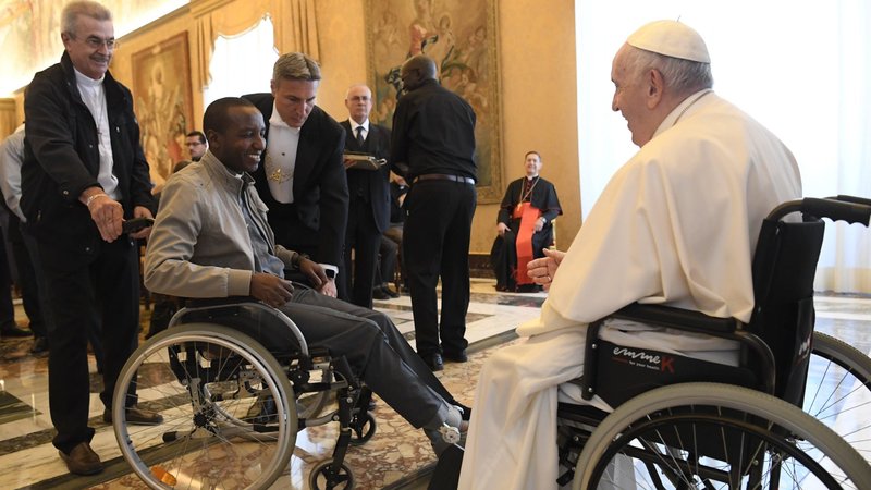 Pope Francis greets a cleric in a wheelchair during an audience with participants attending the general chapter of the Comboni Missionaries, at the Vatican June 18, 2022. (CNS photo/Vatican Media)