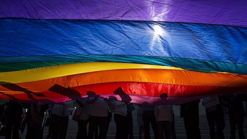 In this 2015 file photo, LGBTQ supporters wave a flag outside the U.S. Supreme Court in Washington. The Catholic Benefits Association amended an ongoing lawsuit it filed in October 2023 that seeks relief from the U.S. Department of Health and Human Services' regulation prohibiting health care providers and insurers that receive federal funding from discriminating against patients who seek treatment related to their gender identity or sexual orientation. (OSV News photo/Tyler Orsburn, CNS archive)