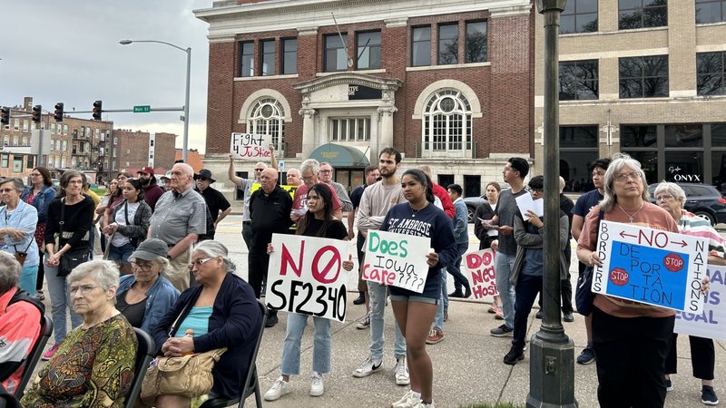 Participants at the "For Human Dignity" vigil/rally outside St. Anthony Catholic Church in Davenport, Iowa, May 1, 2024, hold placards protesting Iowa's new law that makes it a state crime for illegal reentry into Iowa. A U.S. District Court judge June 17 issued a preliminary injunction preventing the law from taking effect July 1. (OSV News photo/Barb Arland-Fye, The Catholic Messenger)