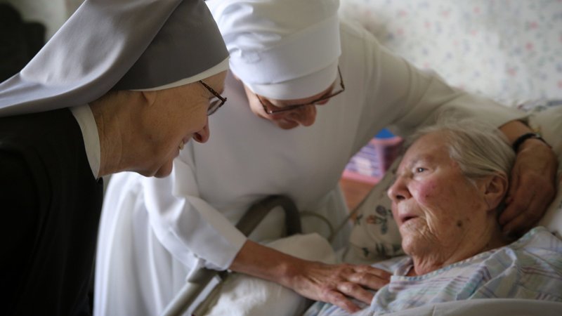 Nuns are pictured in a file photo comforting a frail resident at Little Sisters of the Poor Jeanne Jugan Residence in San Pedro, Calif. (CNS photo/courtesy Little Sisters of the Poor)