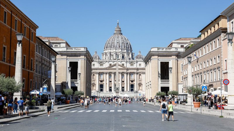 Pilgrims and tourists walk along the Via della Conciliazione toward St. Peter's Square and St. Peter's Basilica Aug. 15, 2023. The broad avenue is lined with many Vatican-owned buildings either used for Vatican offices and residences or rented out to earn money. (CNS photo/Lola Gomez)