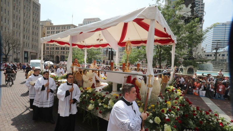 Bishop Andrew H. Cozzens of Crookston, Minn., chairman of the board of the National Eucharistic Congress, Inc., and Archbishop Charles C. Thompson of Indianapolis, kneel before the Blessed Sacrament being towed during the final Eucharistic procession of the National Eucharistic Congress in downtown Indianapolis July 20, 2024. (OSV News/Bob Roller)