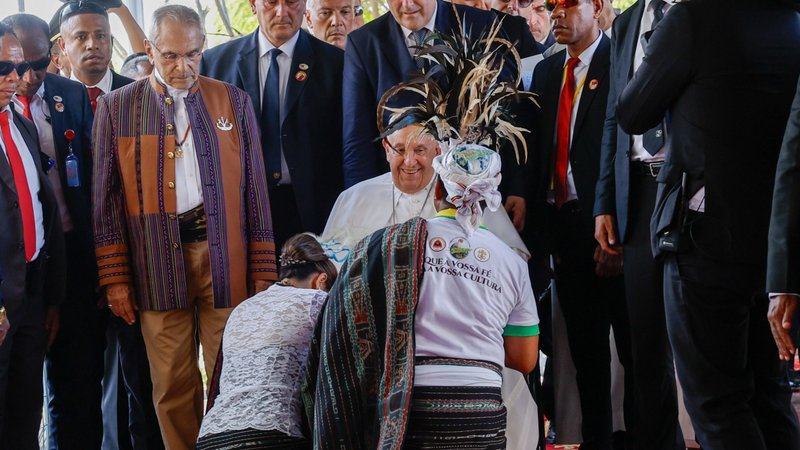 Pope Francis is greeted by two women in traditional dress as he is welcomed to Timor-Leste at Presidente Nicolau Lobato International Airport in Dili Sept. 9, 2024. (CNS photo/Lola Gomez)