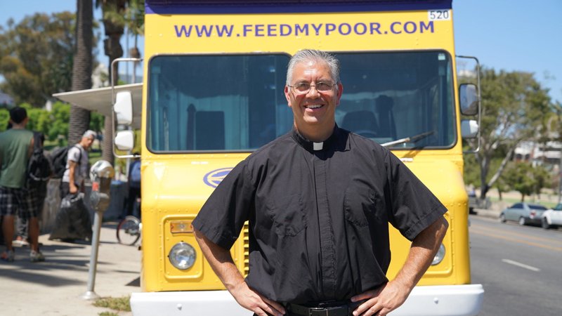 Father Ed Benioff, pastor at Church of the Good Shepherd in Beverly Hills, stands in front of the Feed My Poor food truck that brings hot meals to the needy seven days a week. (John Rueda)
