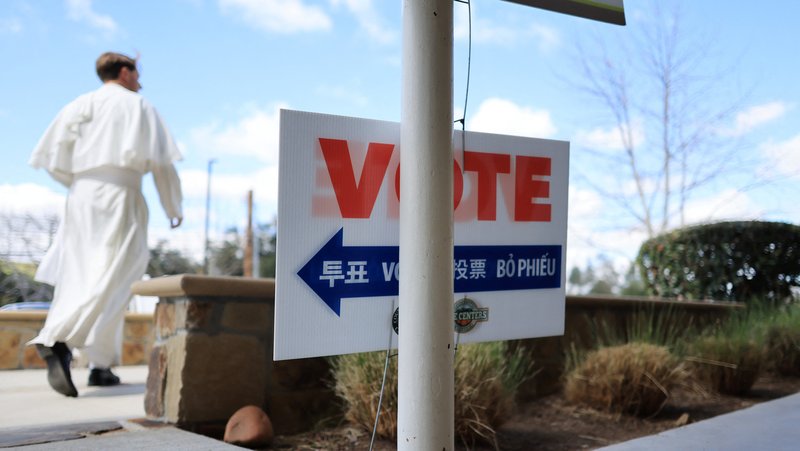 A member of the clergy walks outside a voting station at the Library of the Canyons in Silverado, California, during the Super Tuesday primary election March 5. (OSV News/David Swanson, Reuters)