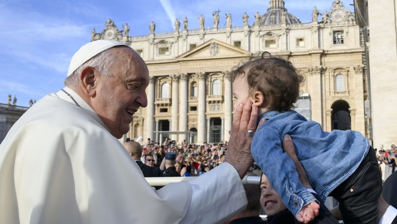 Pope Francis greets a child as he rides in the popemobile before his general audience in St. Peter's Square at the Vatican Oct. 9, 2024. (CNS photo/Vatican Media)