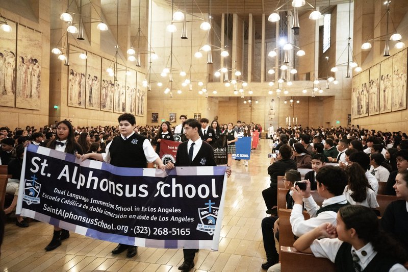 Students from St. Alphonsus School in East LA hold up a sign during the procession to begin the annual Missionary Childhood Association Youth Appreciation Mass on Oct. 16. (Victor Alemán)